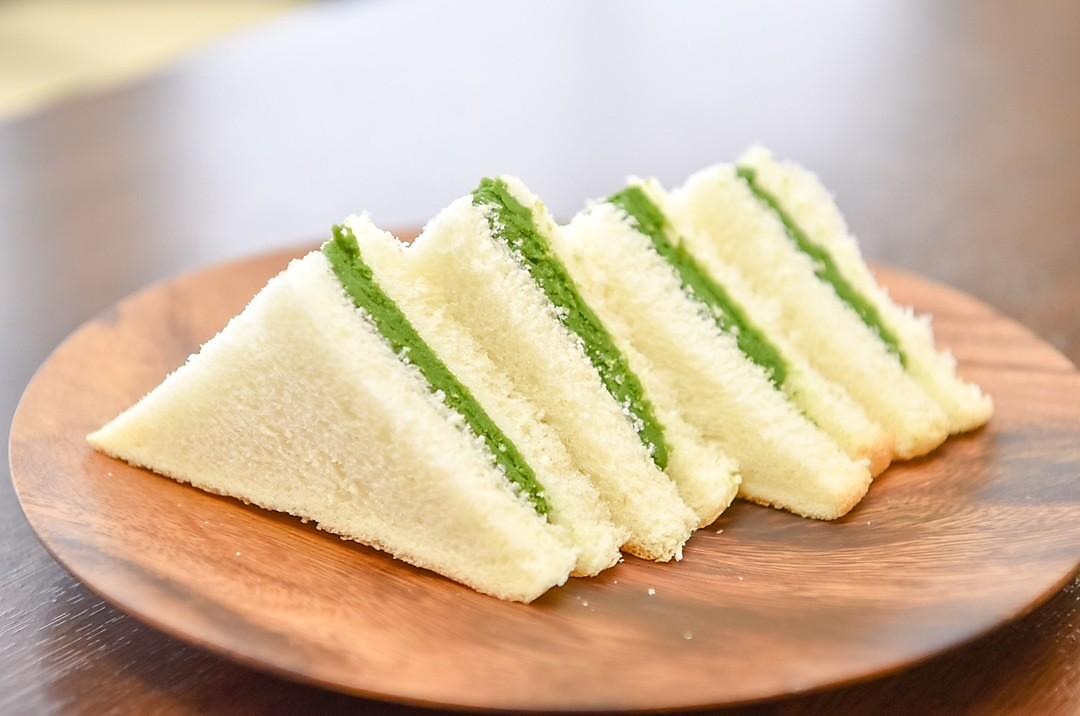 Kuwa Matcha green cream sandwiches on a wooden plate